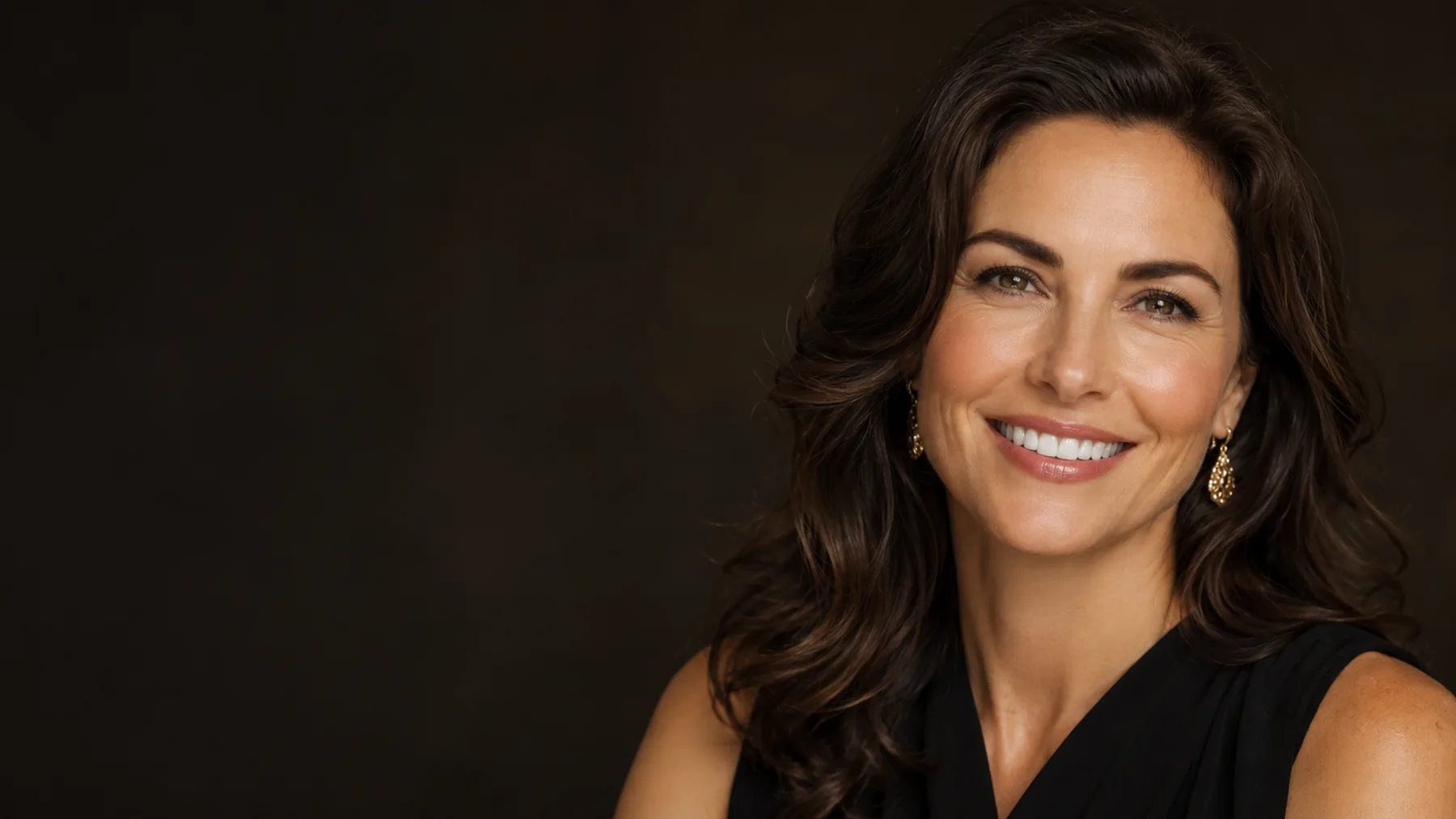 Elegant woman with a radiant smile against a dark espresso background